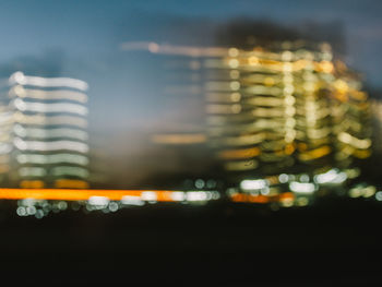 Illuminated city street against sky at night