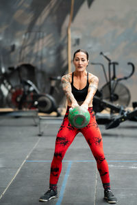 Portrait of young woman exercising in gym