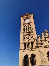 Low angle view of clock tower against clear blue sky