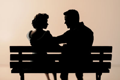 Silhouette man and woman standing against wall