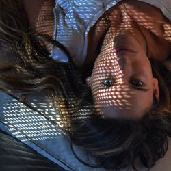 Upside down portrait image of young woman lying on wooden floor