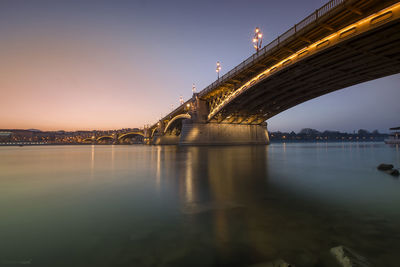 Illuminated suspension bridge over river at night