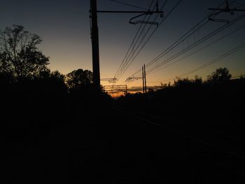 Electricity pylon against sky at sunset