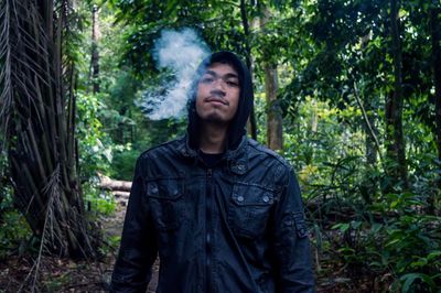 Portrait of a young man standing in forest