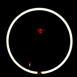 Close-up of illuminated red lights against black background