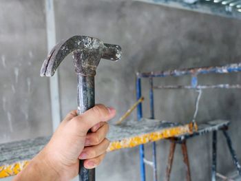 Close-up of hand holding hammer at construction site