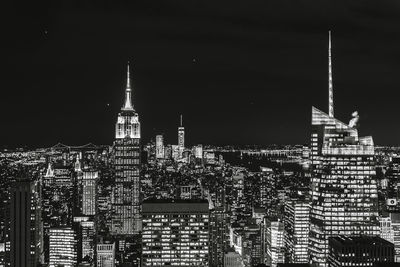 Illuminated cityscape against sky at night