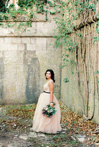 Rear view of woman standing against wall