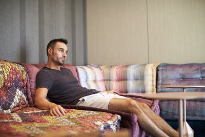 A man relaxes on a comfortable modern couch.