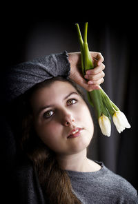 Portrait of beautiful young woman against black background