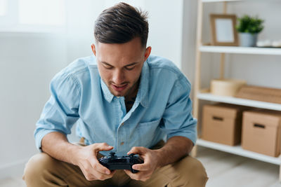 Young man using mobile phone at home