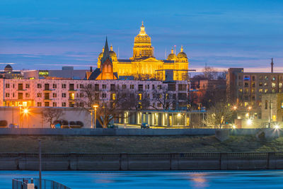 Illuminated buildings against sky in city at dusk