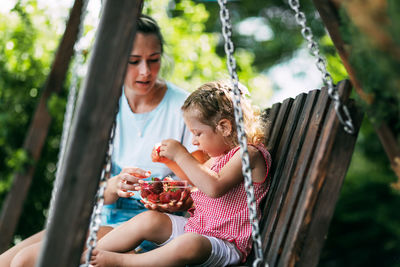 Mother and daughter sitting outdoors