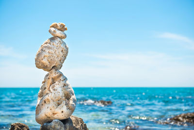 Zen stones balance at stony beach and sea background