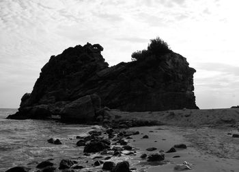 Rocks on beach against sky