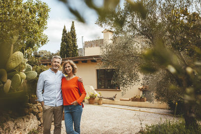 Happy mature woman standing with man in back yard