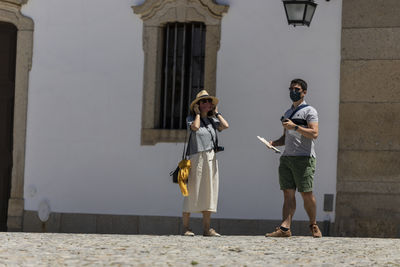 Full length of a man holding woman standing against building