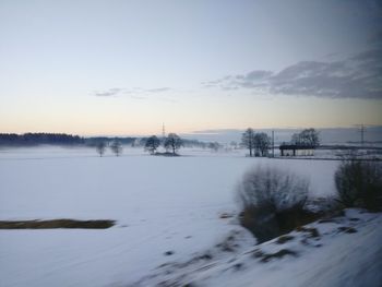 Scenic view of snow covered lake against sky during sunset