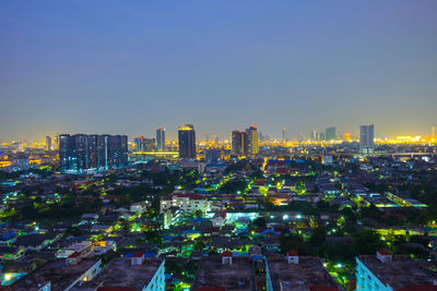 Aerial view of buildings in city against clear sky
