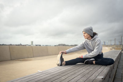 Sporty woman doing leg stretching exercises, outside. outdoor workout.