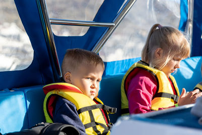 Cute sibling sitting in boat