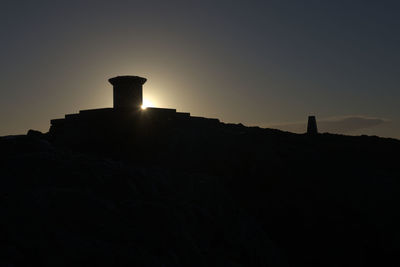 Low angle view of silhouette rocks against sky during sunset