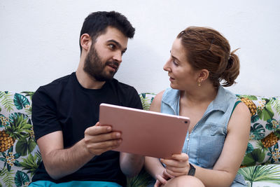 Young man looking away while using smart phone