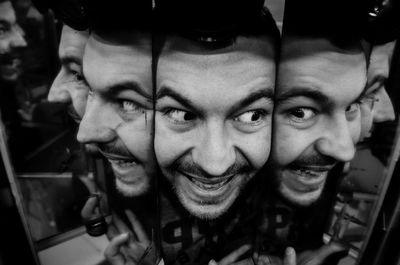 Close-up of smiling young man amidst mirrors