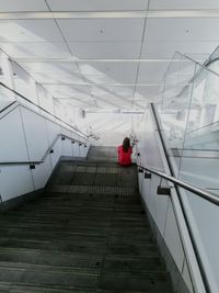 Rear view of woman sitting on staircase