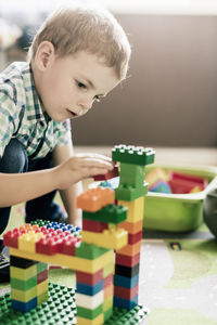 Boy playing with toy blocks at home