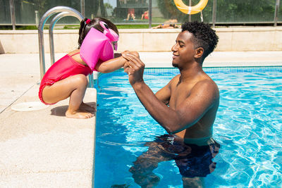 Father and daughter having fun in pool