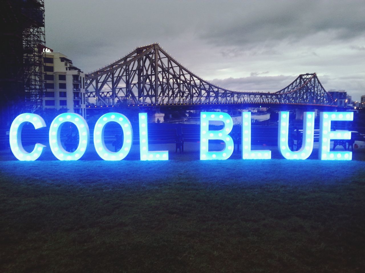 text, western script, communication, sky, capital letter, sign, low angle view, information, information sign, non-western script, guidance, cloud - sky, built structure, architecture, road sign, illuminated, no people, cloud, cloudy, outdoors