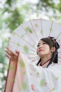 Portrait of young woman holding umbrella