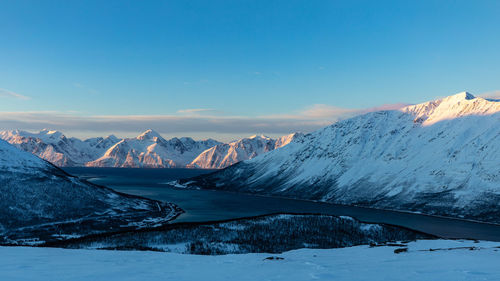 Scenic view of snowcapped mountains against blue sky