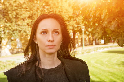 Portrait of a woman in a park in a coat on a sunny spring day