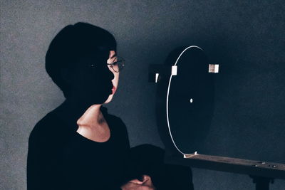 Woman standing by audio equipment in recording studio