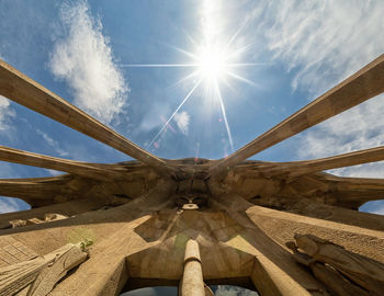 Low angle view of wood against sky on sunny day