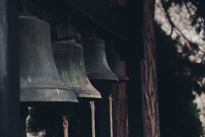 Low angle view of electric lamp hanging by old building