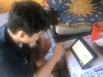 High angle view of boy sitting on table at home