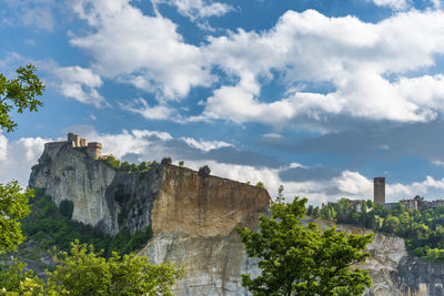 Rock formations on mountain against cloudy sky