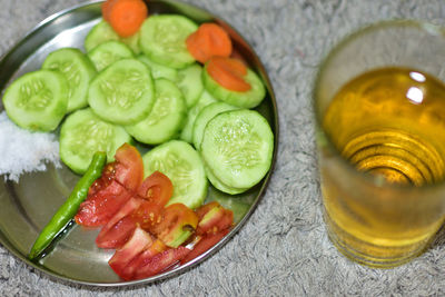 High angle view of fruits salad and wine glass in plate on table.