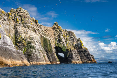 Rock formations in sea against sky