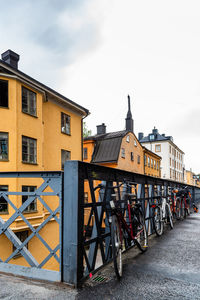 Bicycles on street by buildings against sky