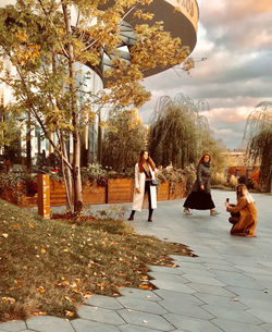 People sitting in park against buildings