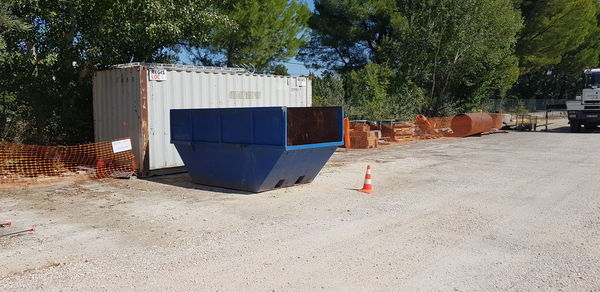 Garbage bin against trees and building