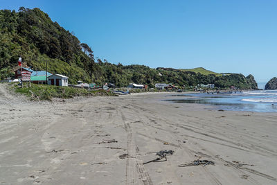 Scenic view of beach against clear blue sky