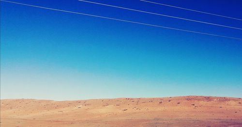 Scenic view of desert against clear blue sky