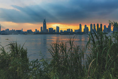 Scenic view of sea and buildings against sky during sunset