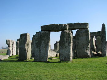 Stone wall on field against clear sky