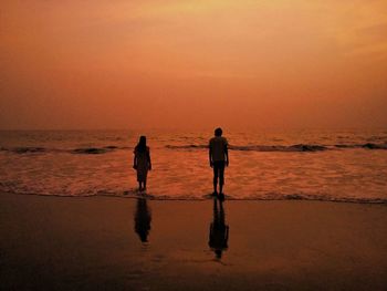 Full length of father at beach against sky during sunset